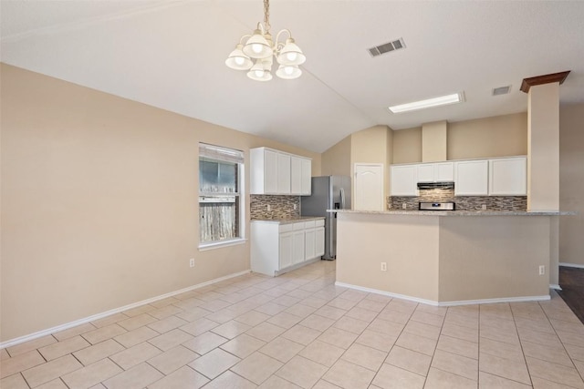 1008 NE Chippewa St, Round Rock, TX 78665 - kitchen with stainless steel refrigerator with ice dispenser, vaulted ceiling, decorative backsplash, a chandelier, and white cabinets