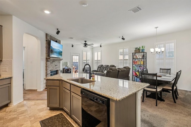 657 Bailey Park Dr, Jarrell, TX 76537 - kitchen with dishwasher, arched walkways, open floor plan, a fireplace, and light stone countertops