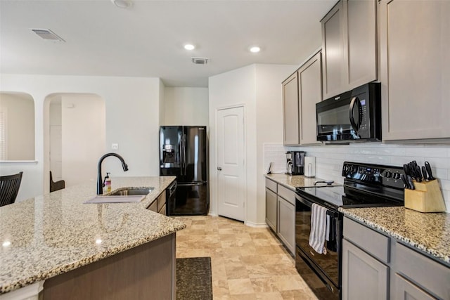 657 Bailey Park Dr, Jarrell, TX 76537 - kitchen with black appliances, decorative backsplash, gray cabinetry, light stone counters, and recessed lighting