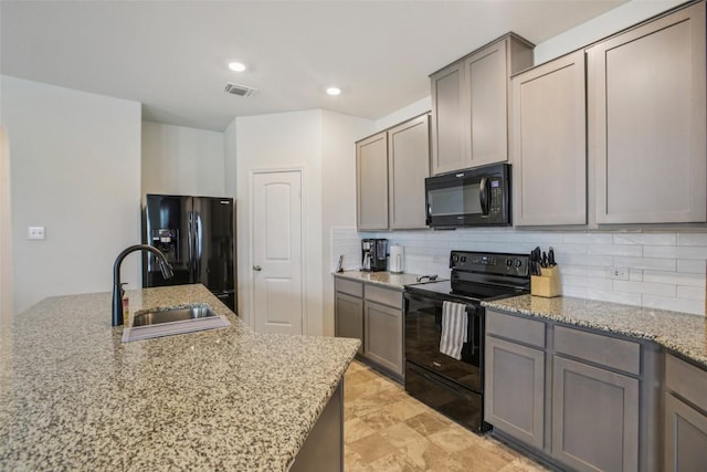 657 Bailey Park Dr, Jarrell, TX 76537 - kitchen with black appliances, decorative backsplash, gray cabinets, and recessed lighting