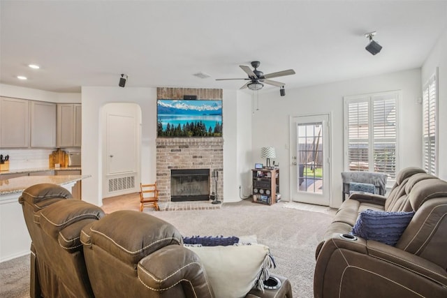 657 Bailey Park Dr, Jarrell, TX 76537 - living area with light colored carpet, plenty of natural light, ceiling fan, a brick fireplace, and recessed lighting