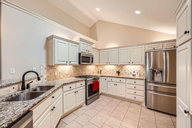 30 Wildwood Dr Unit 92, Georgetown, TX 78633 - kitchen featuring appliances with stainless steel finishes, vaulted ceiling, tasteful backsplash, light stone countertops, and recessed lighting
