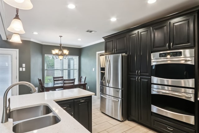 11611 Quarter Horse Trl, Austin, TX 78750 - kitchen featuring appliances with stainless steel finishes, dark cabinetry, pendant lighting, a chandelier, and ornamental molding