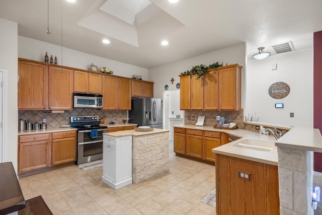 313 Polo Pony, Liberty Hill, TX 78642 - kitchen with appliances with stainless steel finishes, a peninsula, light countertops, decorative backsplash, and recessed lighting