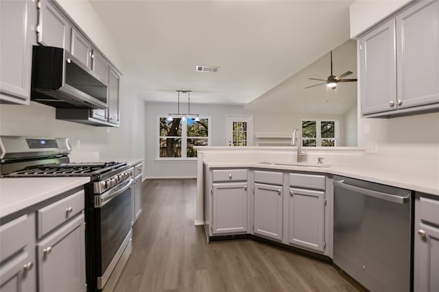6900 Tesoro Trl, Austin, TX 78729 - kitchen featuring stainless steel appliances, a peninsula, dark wood-style floors, a ceiling fan, and light countertops