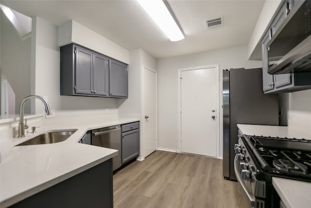 6900 Tesoro Trl, Austin, TX 78729 - kitchen featuring stainless steel appliances, light wood-style flooring, light countertops, and gray cabinets