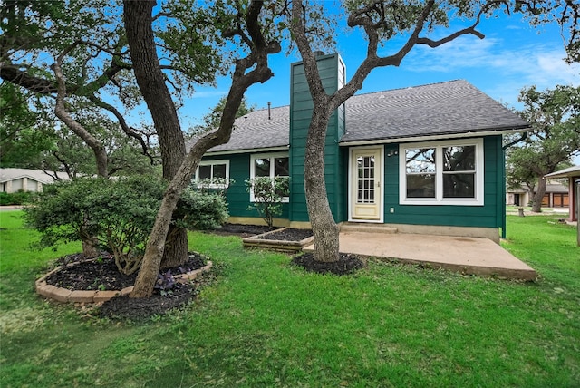 6900 Tesoro Trl, Austin, TX 78729 - rear view of property featuring a yard, a shingled roof, and a chimney