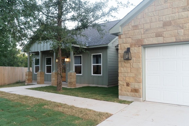 118 Kipapa Ct, Bastrop, TX 78602 - view of front of home with a shingled roof, concrete driveway, a garage, board and batten siding, and stone siding