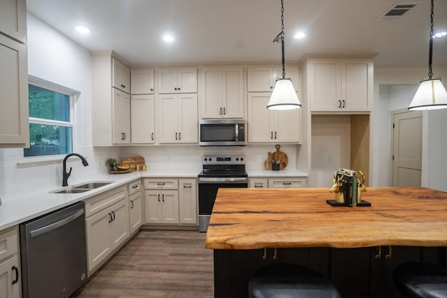118 Kipapa Ct, Bastrop, TX 78602 - kitchen with stainless steel appliances, butcher block countertops, a kitchen bar, tasteful backsplash, and recessed lighting