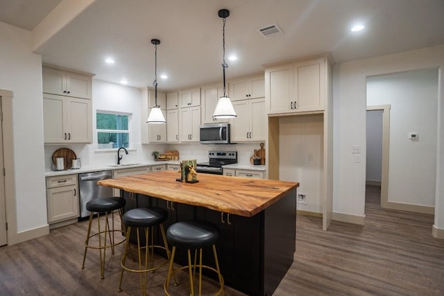118 Kipapa Ct, Bastrop, TX 78602 - kitchen featuring stainless steel appliances, wood counters, tasteful backsplash, dark wood-style floors, and recessed lighting