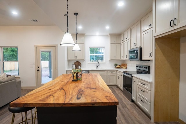 118 Kipapa Ct, Bastrop, TX 78602 - kitchen featuring appliances with stainless steel finishes, dark wood-type flooring, wooden counters, tasteful backsplash, and a kitchen island
