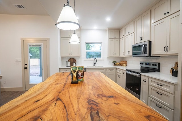 118 Kipapa Ct, Bastrop, TX 78602 - kitchen with butcher block countertops, stainless steel appliances, decorative backsplash, and recessed lighting