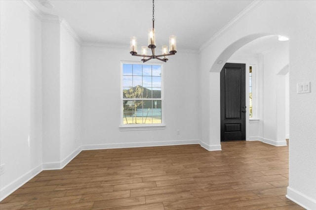 4121 Turning Leaf Dr, Nolanville, TX 76559 - unfurnished dining area with a chandelier, arched walkways, crown molding, and wood finished floors
