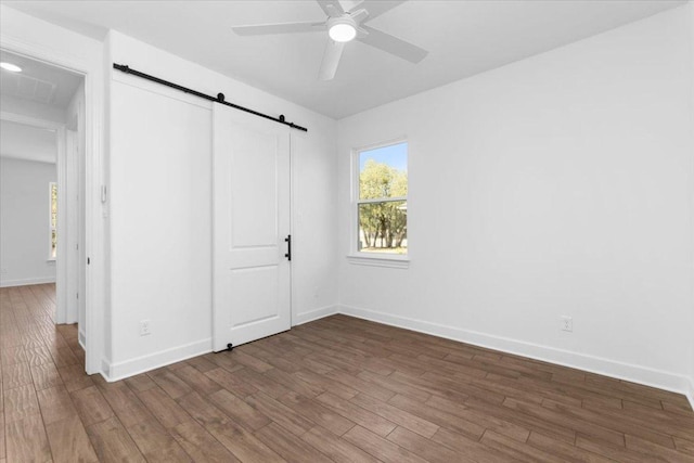 4113 Turning Leaf Dr, Nolanville, TX 76559 - unfurnished bedroom with a barn door, wood finished floors, multiple windows, and a closet