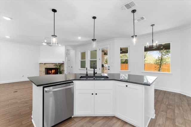 4113 Turning Leaf Dr, Nolanville, TX 76559 - kitchen featuring dishwasher, crown molding, a warm lit fireplace, wood finished floors, and recessed lighting
