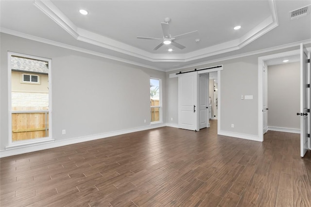 7026 Troyan, Temple, TX 76502 - unfurnished bedroom with a tray ceiling, a barn door, dark wood-style flooring, ornamental molding, and a ceiling fan