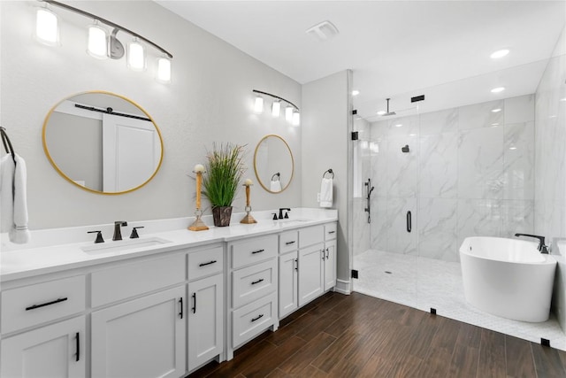 7026 Troyan, Temple, TX 76502 - bathroom with a marble finish shower, double vanity, a freestanding bath, wood finished floors, and recessed lighting