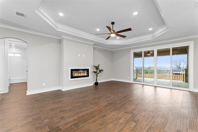 7026 Troyan, Temple, TX 76502 - unfurnished living room featuring a tray ceiling, a ceiling fan, arched walkways, dark wood finished floors, and recessed lighting