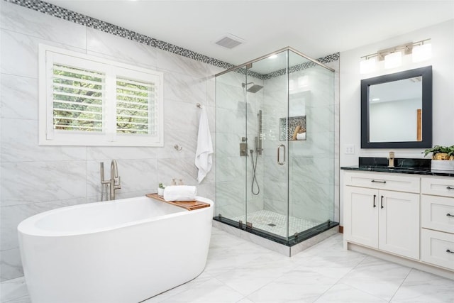 4604 Fawnwood Cv, Austin, TX 78735 - full bathroom featuring marble finish flooring, vanity, a soaking tub, a shower stall, and tile walls