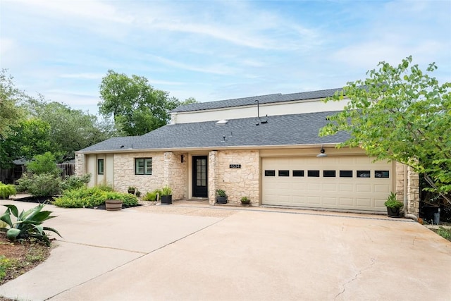 4604 Fawnwood Cv, Austin, TX 78735 - view of front facade with concrete driveway, stone siding, a garage, and roof with shingles