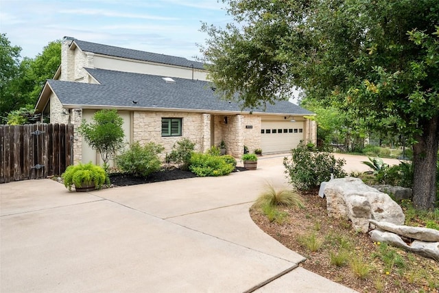 4604 Fawnwood Cv, Austin, TX 78735 - view of front facade with driveway, stone siding, an attached garage, and roof with shingles