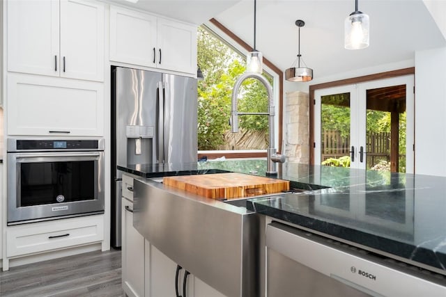 4604 Fawnwood Cv, Austin, TX 78735 - kitchen featuring oven, french doors, white cabinets, pendant lighting, and dark stone countertops