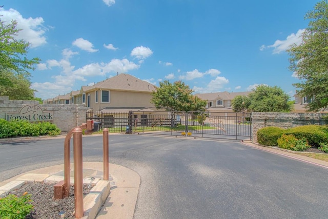 3300 Forest Creek Dr Unit 45, Round Rock, TX 78664 - view of asphalt road with a gate, a gated entry, curbs, and a residential view
