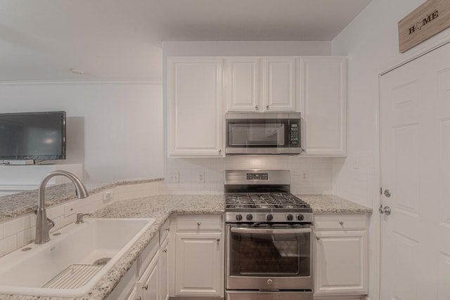 3300 Forest Creek Dr Unit 45, Round Rock, TX 78664 - kitchen with stainless steel appliances, white cabinetry, decorative backsplash, light stone counters, and a peninsula