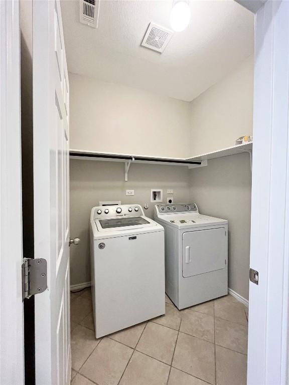 139 Diamondback Cv, Buda, TX 78610 - washroom with independent washer and dryer and light tile patterned floors