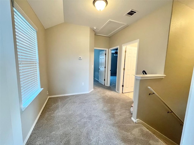 139 Diamondback Cv, Buda, TX 78610 - unfurnished bedroom featuring carpet floors, attic access, multiple windows, and vaulted ceiling