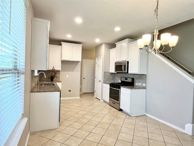 139 Diamondback Cv, Buda, TX 78610 - kitchen with stainless steel appliances, decorative backsplash, light tile patterned floors, dark stone counters, and recessed lighting