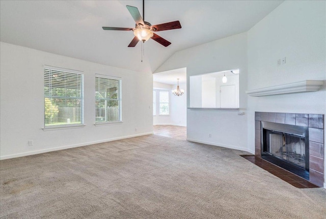 233 Sunshadow Dr, Lockhart, TX 78644 - unfurnished living room featuring carpet flooring, a chandelier, a fireplace, vaulted ceiling, and a ceiling fan