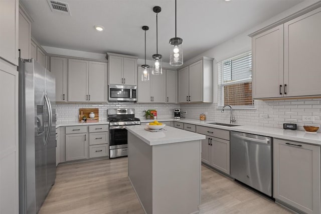 13506 Grand Central Dr, Pflugerville, TX 78660 - kitchen with stainless steel appliances, gray cabinetry, light wood-style flooring, tasteful backsplash, and recessed lighting