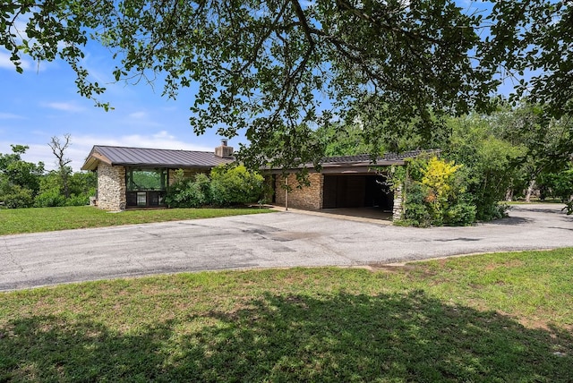 1200 Redbud Trl, West Lake Hills, TX 78746 - view of front of home with a standing seam roof, asphalt driveway, a chimney, a front yard, and a metal roof