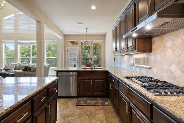 8709 Fescue Ln, Austin, TX 78738 - kitchen featuring under cabinet range hood, stainless steel appliances, a chandelier, dark brown cabinetry, and recessed lighting
