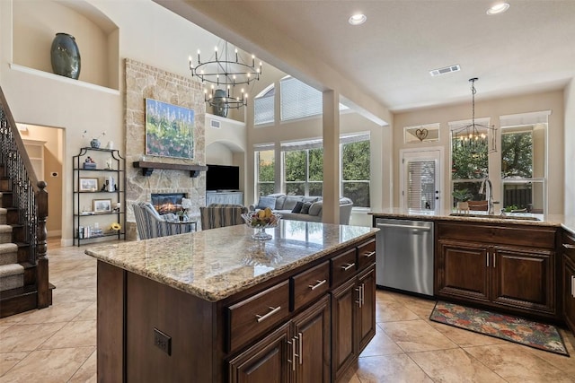 8709 Fescue Ln, Austin, TX 78738 - kitchen with stainless steel dishwasher, a chandelier, a stone fireplace, light tile patterned floors, and recessed lighting