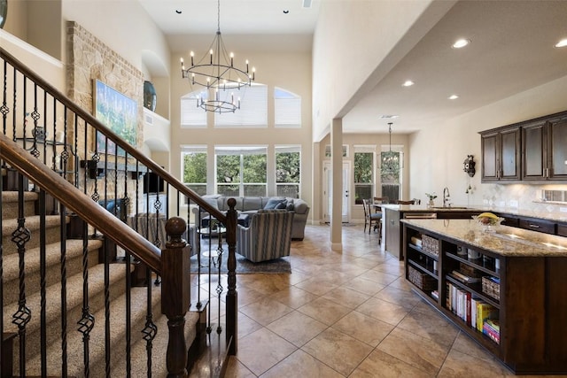 8709 Fescue Ln, Austin, TX 78738 - stairway with recessed lighting, a chandelier, tile patterned flooring, and a high ceiling
