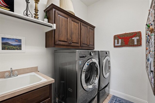 8709 Fescue Ln, Austin, TX 78738 - washroom featuring washing machine and dryer, cabinet space, and light tile patterned flooring