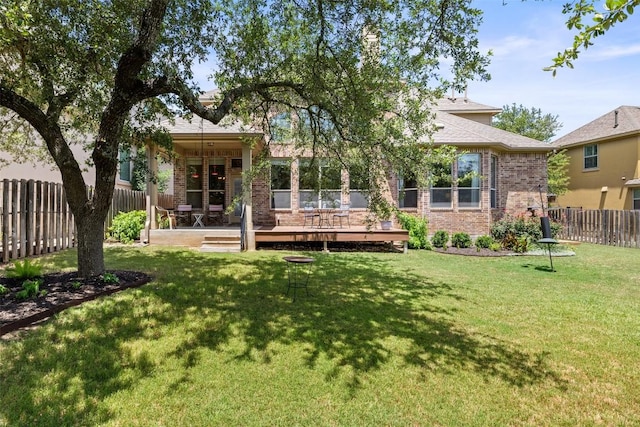 8709 Fescue Ln, Austin, TX 78738 - back of property featuring brick siding, a fenced backyard, and a deck