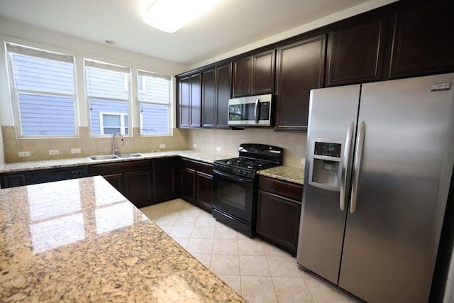 151 Campos, Kyle, TX 78640 - kitchen with appliances with stainless steel finishes, tasteful backsplash, light tile patterned floors, light stone counters, and dark brown cabinetry