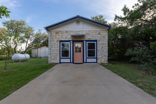 13100 N Ridge Cir, Leander, TX 78641 - view of front of home featuring stone siding, a front lawn, and an outbuilding