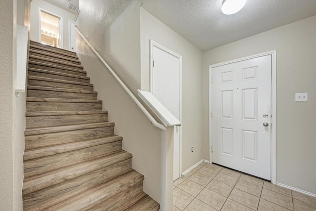 3417 Tralagon Trl, Pflugerville, TX 78660 - foyer featuring stairway, light tile patterned floors, and a textured ceiling