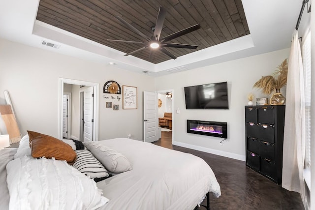 102 Moku Ct, Bastrop, TX 78602 - bedroom with a tray ceiling, wood ceiling, a glass covered fireplace, and ceiling fan