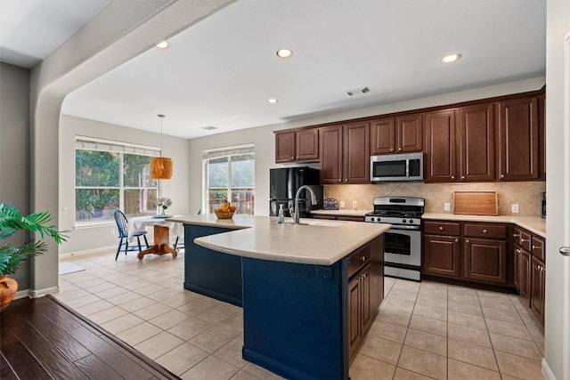 2611 Terlingua Dr, Cedar Park, TX 78613 - kitchen with stainless steel appliances, light countertops, backsplash, recessed lighting, and a center island with sink