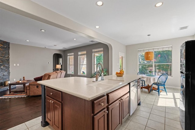 2611 Terlingua Dr, Cedar Park, TX 78613 - kitchen featuring arched walkways, freestanding refrigerator, light tile patterned floors, light countertops, and stainless steel dishwasher