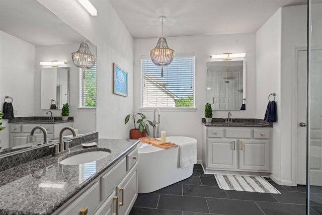 2611 Terlingua Dr, Cedar Park, TX 78613 - full bathroom featuring a chandelier, two vanities, a walk in shower, a freestanding tub, and tile patterned floors