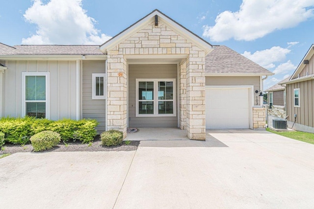 116 Mulligan Dr Unit 103, San Marcos, TX 78666 - view of front of home featuring stone siding, board and batten siding, a garage, driveway, and roof with shingles
