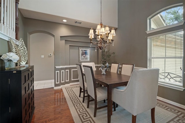 25 Falling Oaks Trl, The Hills, TX 78738 - dining room featuring a chandelier, arched walkways, recessed lighting, wood finished floors, and a towering ceiling