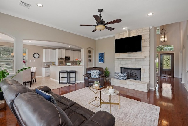 25 Falling Oaks Trl, The Hills, TX 78738 - living area with a ceiling fan, a fireplace, ornamental molding, arched walkways, and healthy amount of natural light