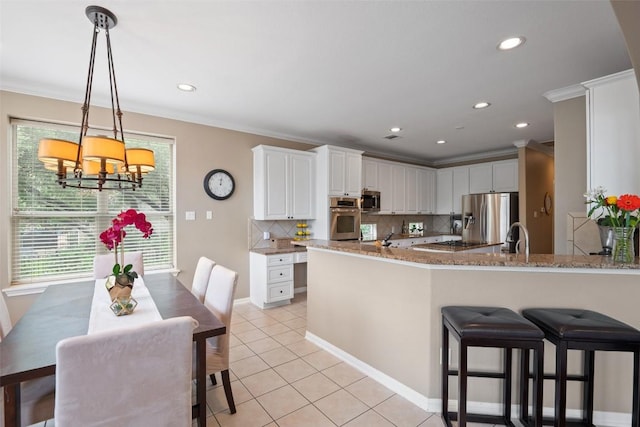 25 Falling Oaks Trl, The Hills, TX 78738 - kitchen with stainless steel appliances, crown molding, decorative backsplash, a chandelier, and white cabinets